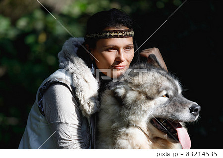 Portrait of a young Caucasian woman with an Alaskan Malamute dog in the autumn forest Portrait of a young Caucasian woman with an Alaskan Malamute dog in the autumn forest 83214535