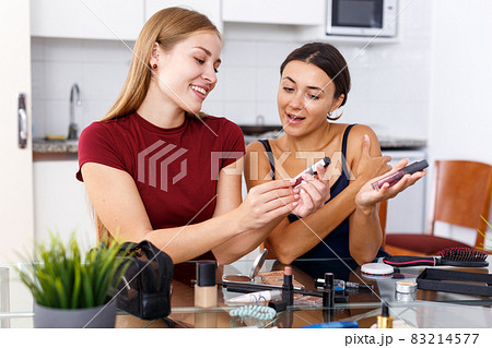 Two modern girls applying make up 83214577
