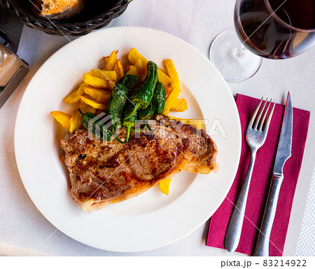 Beef steak with fries and grilled padron peppers Beef steak with fries and grilled padron peppers 83214922