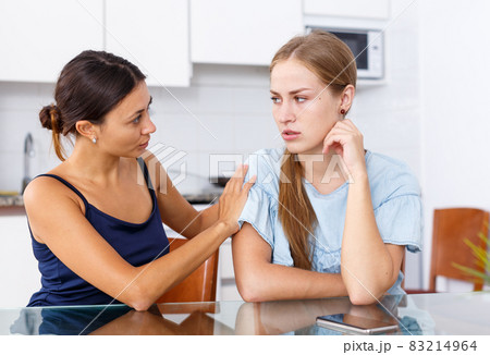 Upset young women discussing, quarrel at home kitchen indoor Upset young women discussing, quarrel at home kitchen indoor 83214964