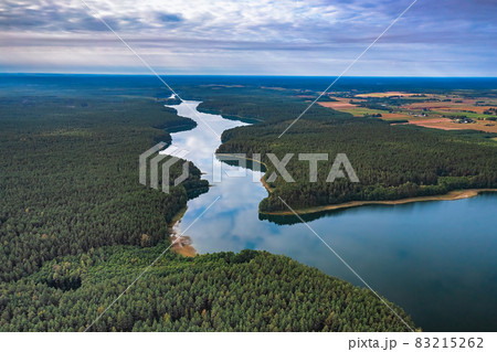 Aerial view of Ancia lake in Lithuania, shiny reflection of sky with clouds in the water of the lake Aerial view of Ancia lake in Lithuania, shiny reflection of sky with clouds in the water of the lake 83215262