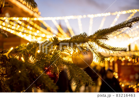 Close-up of a Christmas tree branch with decorative balls, toys and a shining garland. soft focus, background in blur. Close-up of a Christmas tree branch with decorative balls, toys and a shining garland. soft focus, background in blur. 83216463