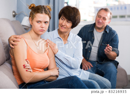 Mom and dad are supporting a sad daughter on sofa Mom and dad are supporting a sad daughter on sofa 83216935