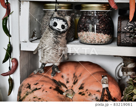 Vintage kitchen still life with voodoo doll, pumpkin, old bottles and jars of potion and witch ritual objects. Provence, rural style. Halloween concept 83219061