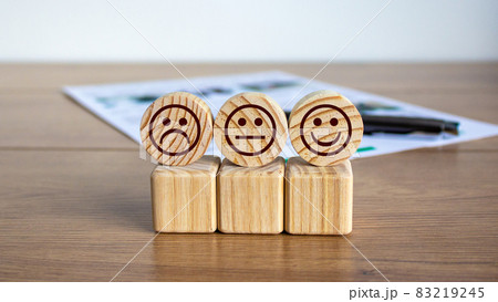 Concept sign of smiles on cubes and circles on a beautiful wooden table, pen and documents. 83219245