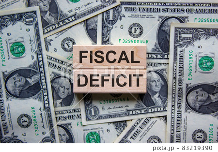 Concept words 'fiscal deficit' on wooden blocks on a beautiful background from dollar bills. Business concept. 83219390
