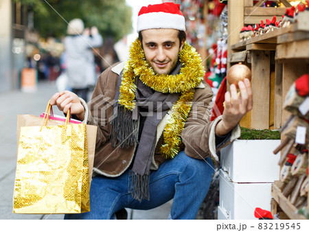 Man expression happinnes from buying decoration at Christmas fair Man expression happinnes from buying decoration at Christmas fair 83219545