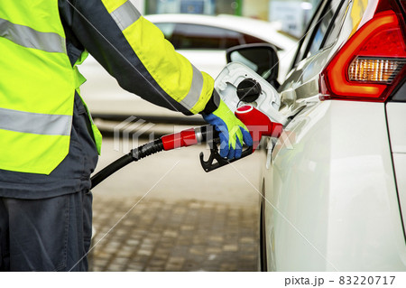 gas station employee in overalls refueling the car gas station employee in overalls refueling the car 83220717