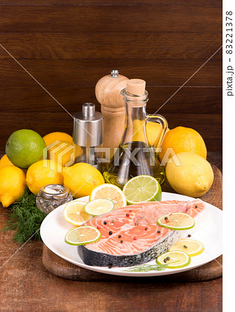Steak of red fish and sliced lemons on wooden table Steak of red fish and sliced lemons on wooden table 83221378