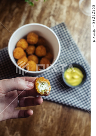 Close-up of potato balls prepared in a fast food restaurant. Barizl national cuisine. Food in a cardboard box. Takeout food. Round buns with potatoes and cheese. 83222558