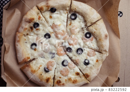 Close-up of pizza with shrimps. Seafood and vegetarian food. Italian food in restaurants and cafes. The concept of marine ingredients in meal preparation. Close-up of pizza with shrimps. Seafood and vegetarian food. Italian food in restaurants and cafes. The concept of marine ingredients in meal preparation. 83222592