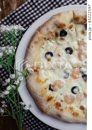 Close-up of pizza with shrimps. Seafood and vegetarian food. Italian food in restaurants and cafes. The concept of marine ingredients in meal preparation. 83222597