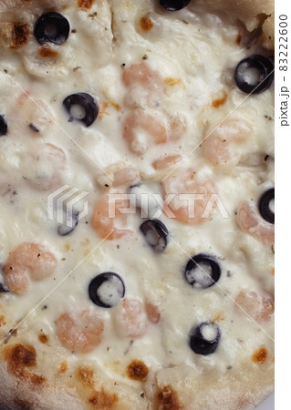 Close-up of pizza with shrimps. Seafood and vegetarian food. Italian food in restaurants and cafes. The concept of marine ingredients in meal preparation. Close-up of pizza with shrimps. Seafood and vegetarian food. Italian food in restaurants and cafes. The concept of marine ingredients in meal preparation. 83222600
