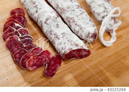 Slicing delicious Spanish smoked sausage fuete Slicing delicious Spanish smoked sausage fuete 83225269