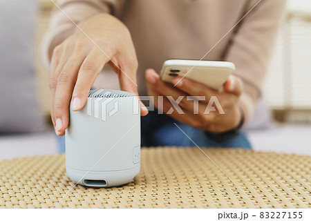 close-up on hand using phone connecting speaker bluetooth 83227155