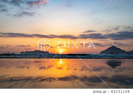 太平洋日向灘に昇る日出で黄昏色に染まった日南海岸の大堂津海水浴場浜と沖に浮かぶ七つ岩と木場島とビロ岩 83231139