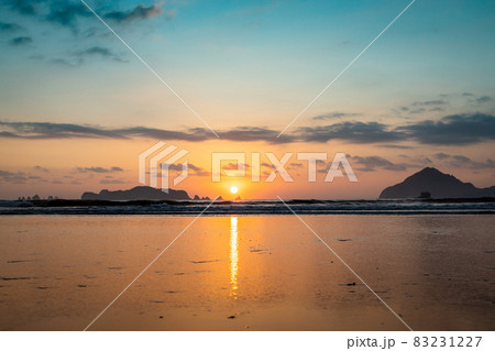 太平洋日向灘に昇る日出で黄昏色に染まった日南海岸の大堂津海水浴場浜と沖に浮かぶ七つ岩と木場島とビロ岩 83231227