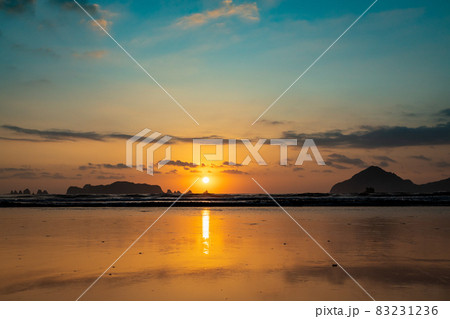 太平洋日向灘に昇る日出で黄昏色に染まった日南海岸の大堂津海水浴場浜と沖に浮かぶ七つ岩と木場島とビロ岩 83231236