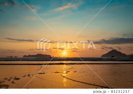 太平洋日向灘に昇る日出で黄昏色に染まった日南海岸の大堂津海水浴場浜と沖に浮かぶ七つ岩と木場島とビロ岩 83231237