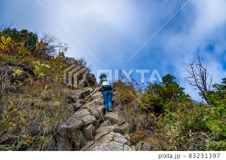 秋の谷川岳・西黒尾根の鎖場を登る登山者 83231397