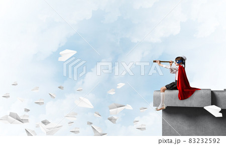 Girl power concept with cute kid guardian against cloudscape background . Mixed media 83232592