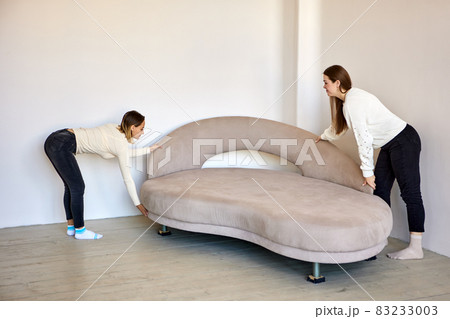 Couple move to new flat and moving furniture indoors. 83233003