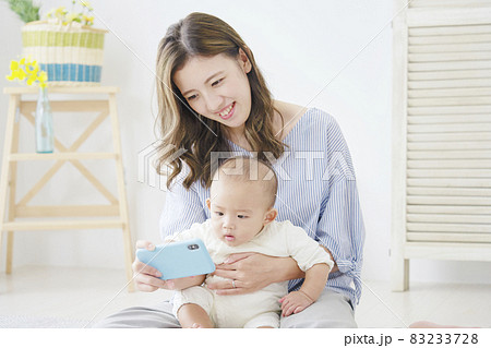 スマホを見る母親と赤ちゃん スマホを見る母親と赤ちゃん 83233728