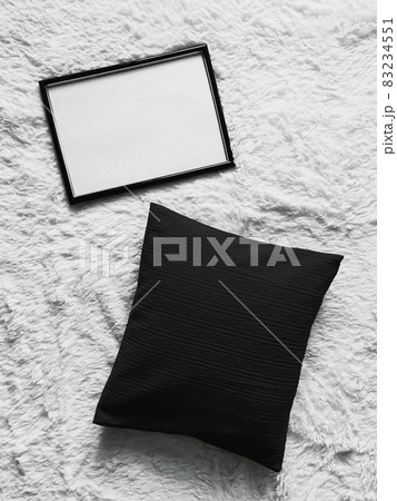 Thin wooden frame with blank copyspace as poster photo print mockup, black cushion pillow and fluffy white blanket, flat lay background and art product Thin wooden frame with blank copyspace as poster photo print mockup, black cushion pillow and fluffy white blanket, flat lay background and art product 83234551