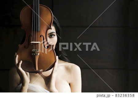 Close up portrait of young asian woman playing violin vintage style. Musician orchestra performer artist lifestyle concept. Close up portrait of young asian woman playing violin vintage style. Musician orchestra performer artist lifestyle concept. 83236358