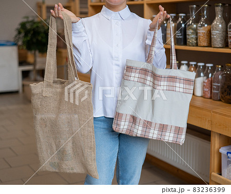 Woman choosing cotton bag at eco-friendly store Woman choosing cotton bag at eco-friendly store 83236399