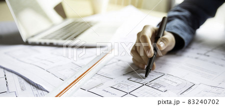 Close up woman hand working of Architect sketching project on blueprint at site construction work. Concept of architect, engineer in the office desk construction project banner 83240702