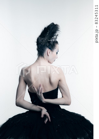 Back view of young ballerina wearing black tutu, stage dress posing isolated on white studio backgorund 83245311