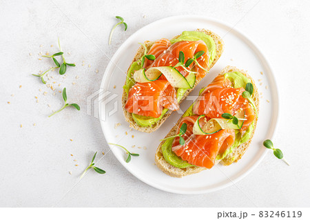 Open sandwiches with salted salmon, guacamole avocado and microgreens. Seafood. Healthy food. Top view. 83246119