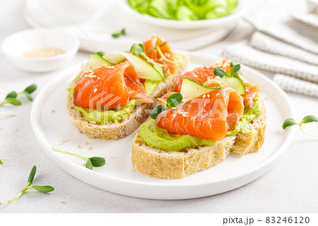 Open sandwiches with salted salmon, guacamole avocado and microgreens. Seafood. Healthy food. 83246120