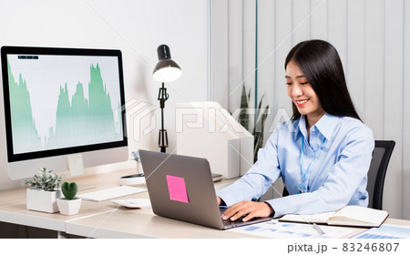 Asian woman working on a laptop with a cheerful and happy smile while working at the office 83246807