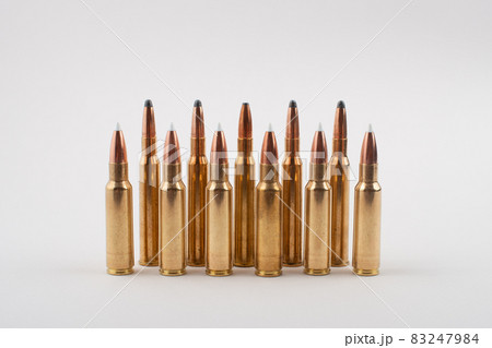 Rifle bullets in a row isolated on grey background. Rifle bullets in a row isolated on grey background. 83247984