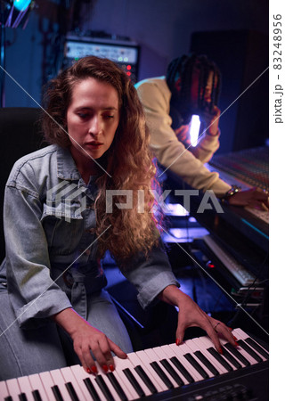 Woman playing synthesizer in the recording studio 83248956