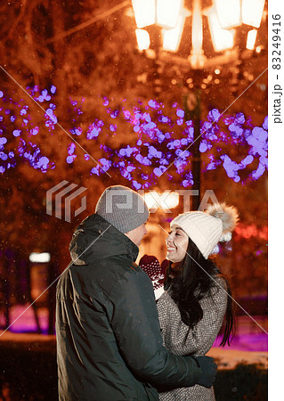 Young couple outdoor in night street at christmas time Young couple outdoor in night street at christmas time 83249416