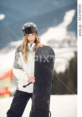 Girl snowboarding in the mountains with the snowboard Girl snowboarding in the mountains with the snowboard 83249505