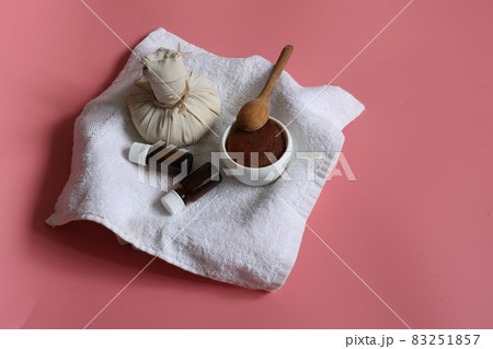 Spa composition with herbal bag, scrub and natural oils on a pink background. 83251857