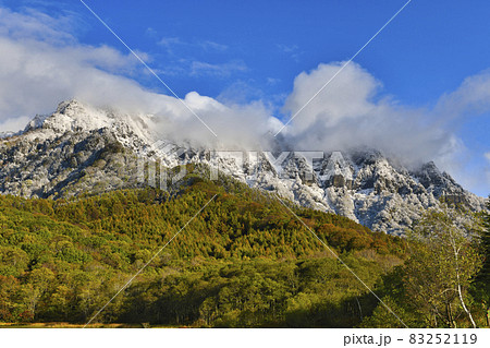 雪化粧した戸隠山と色鮮やかな紅葉 83252119