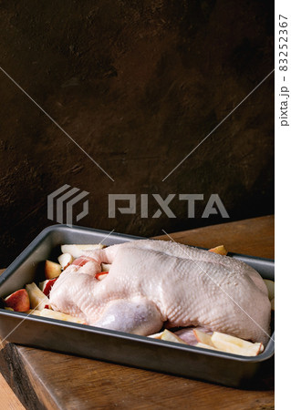 Raw uncooked whole duck in tray with apples 83252367