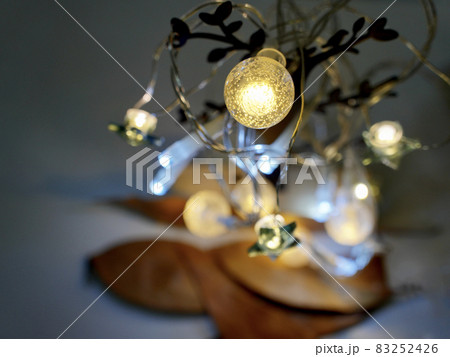 クリスマスの電飾をアイアンツリーに飾り付けテーブルに置く 83252426