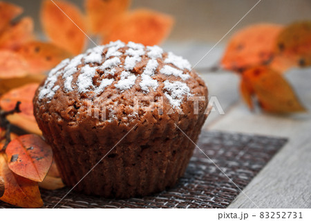 Chocolate muffins with apple filling on a background of autumn leaves and cinnamon Chocolate muffins with apple filling on a background of autumn leaves and cinnamon 83252731
