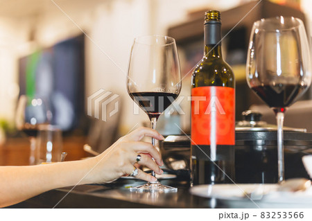 Female hand holding glasses of red wine. 83253566