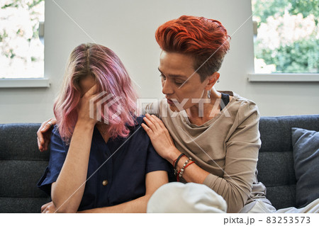 Young couple sitting on the couch and woman is crying while her wife 83253573