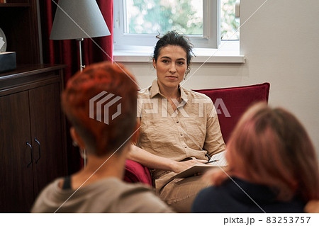 Woman supporting her girlfriend in therapy while listening curiously to the counselor 83253757