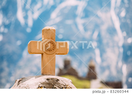 Stepantsminda, Gergeti, Georgia. Cross On Stones On Mountains Background Near Gergeti Trinity Tsminda Sameba Church 83260344