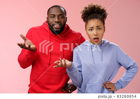 What hell are you doing. Portrait shocked confused clueless two african american friends man woman raise hand dismay shrugging concerned standing frustrated worried cannot understand happening 83260954