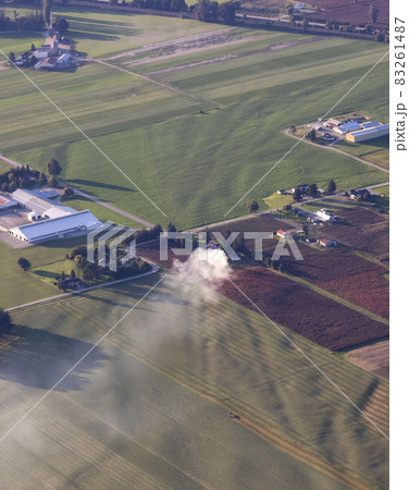 Aerial View of green Farm Field in Fraser Valley with smoke. Aerial View of green Farm Field in Fraser Valley with smoke. 83261487